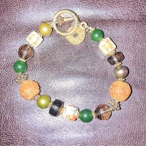 Vintage beaded bracelet with toggle clasp and coin charm. 7” long.